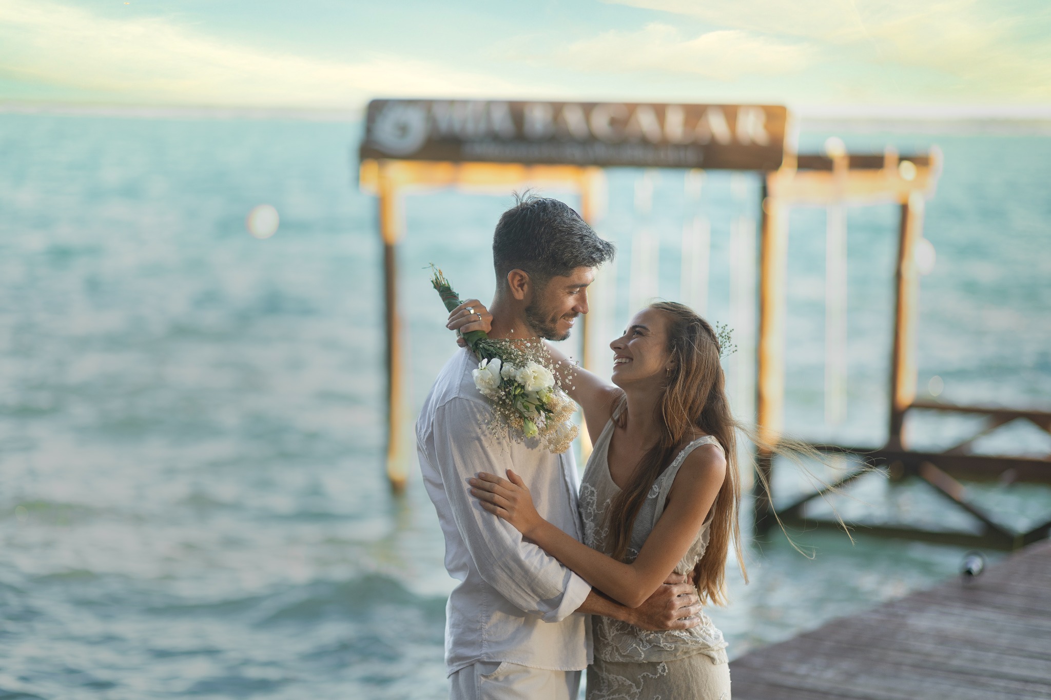 Pareja celebrando frente al muelle de Mía Bacalar